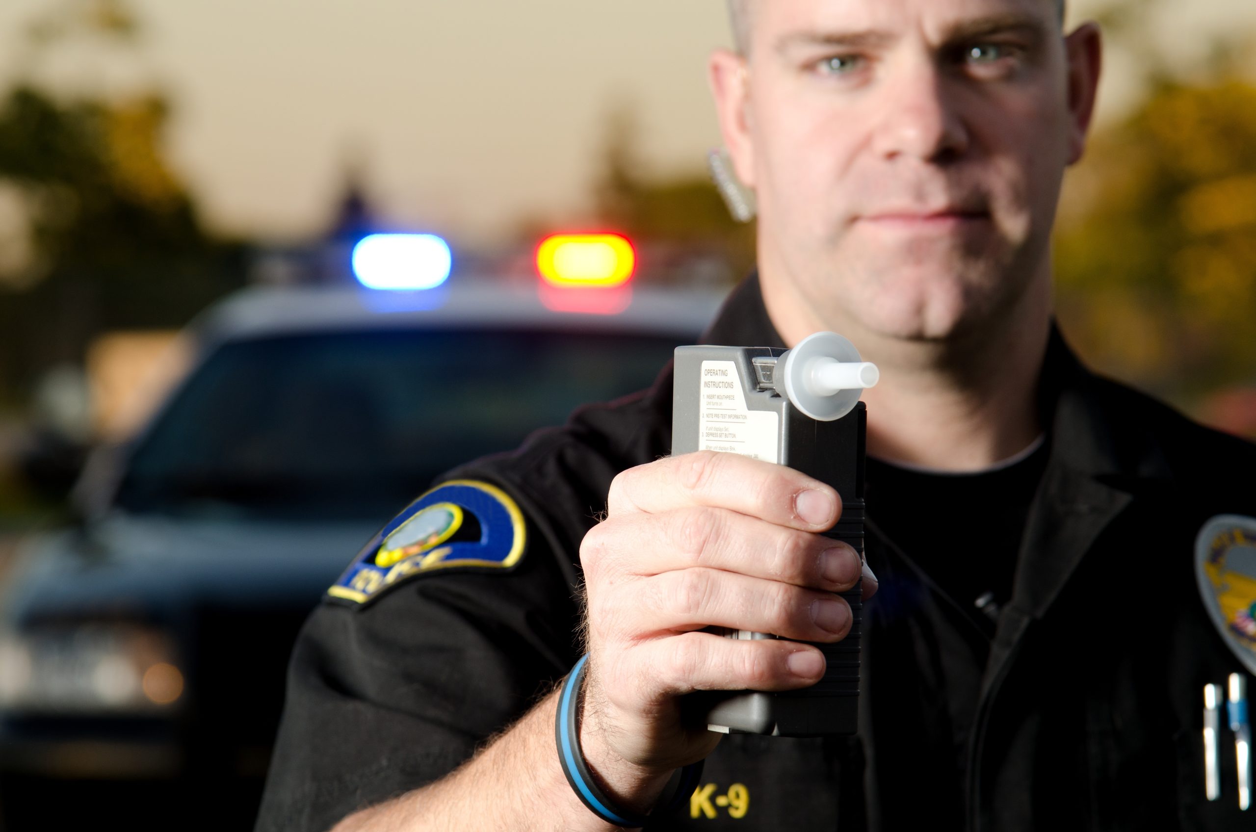 a police officer holds up a breathalyzer device