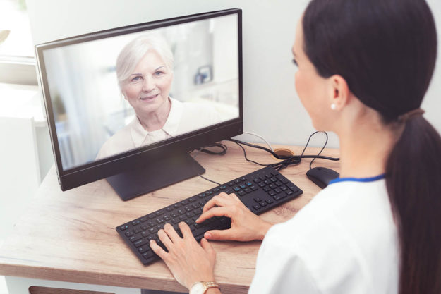 woman on computer receiving telehealth services